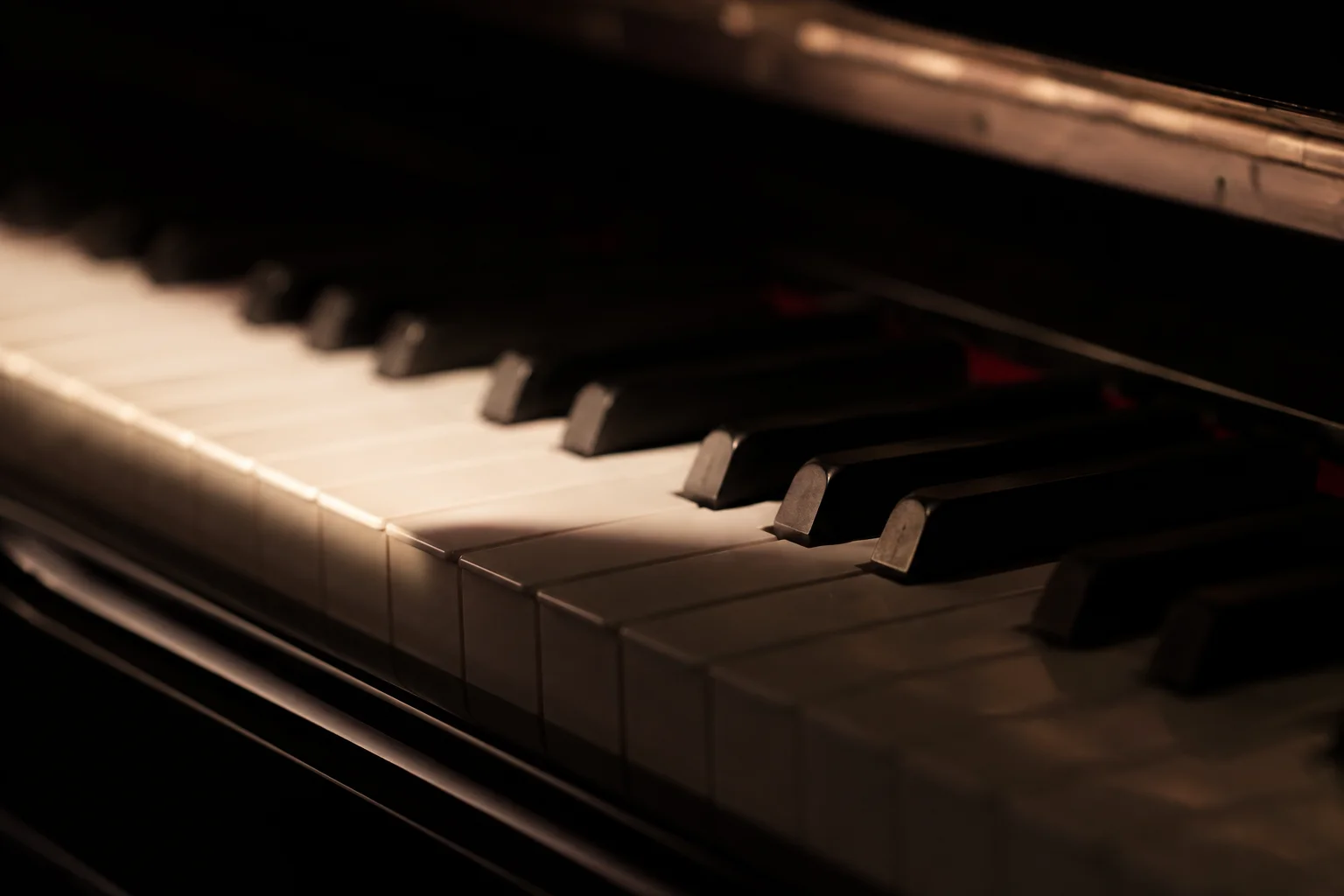 Nahaufnahme der Klaviertasten eines Flügels im warmen Gegenlicht — Klavierunterricht im Tonstudio der ARTIQ Musikschule Mainz-Finthen